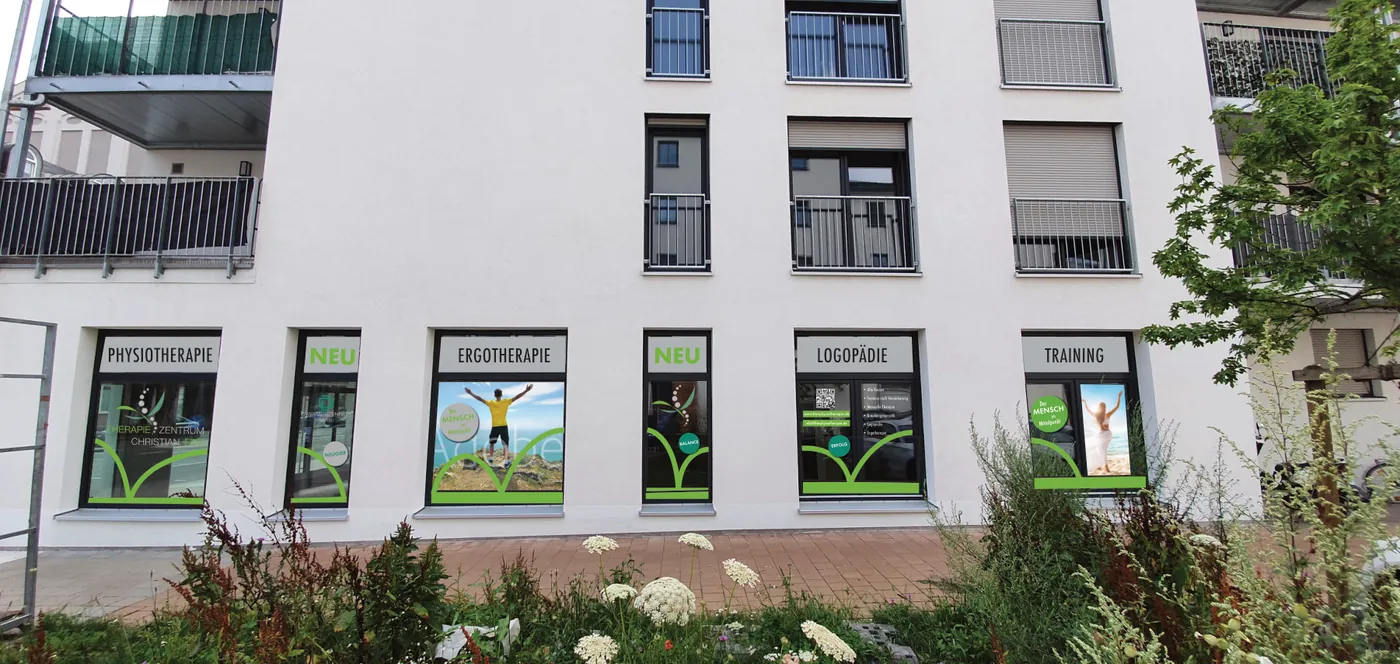 Schaufensterwerbung eines Therapiezentrums mit Physiotherapiepraxis in Fürth mit sechs beklebten Fenstern für Physiotherapie, Ergotherapie, Logopädie und Training